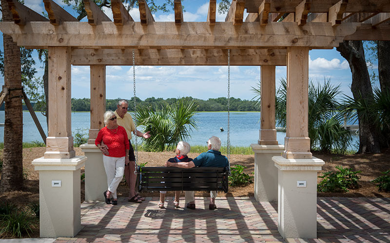 Senior Living Residents enjoying the Porch Swing Overlooking the Water