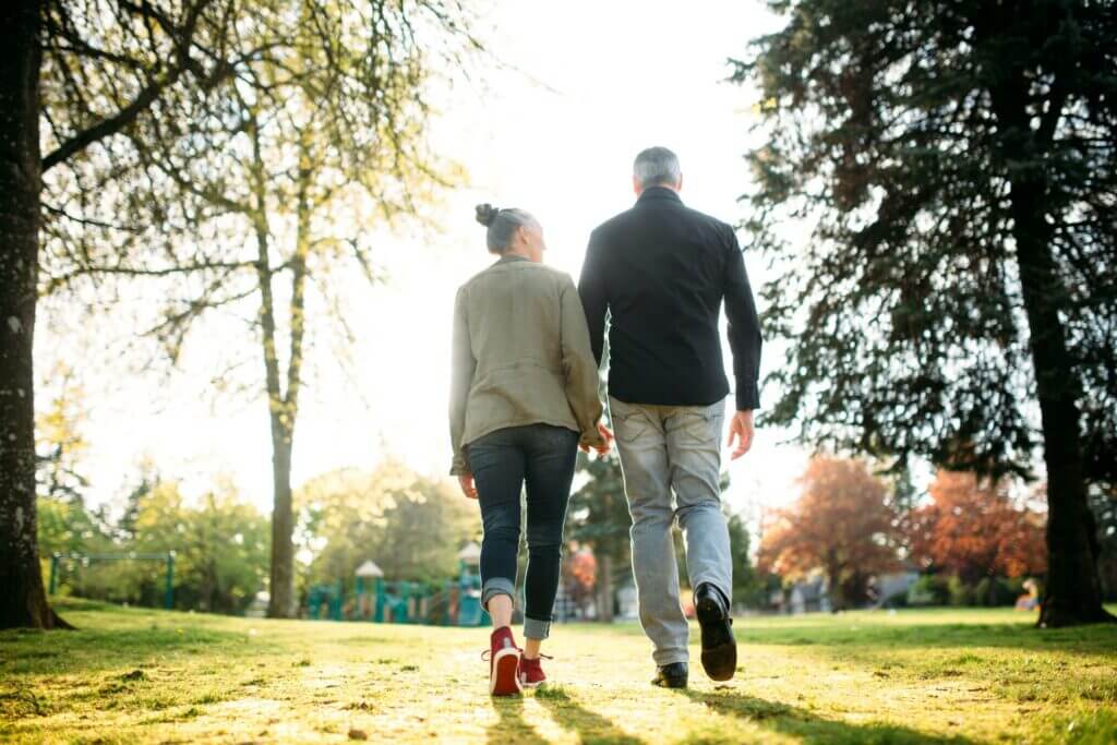 Seniors walking together in a park near a playground