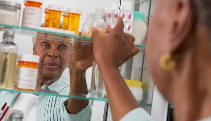 senior woman looking in medicine cabinet
