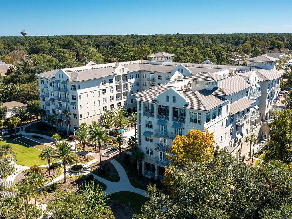 Aerial view of a large residential building surrounded by trees and pathways.