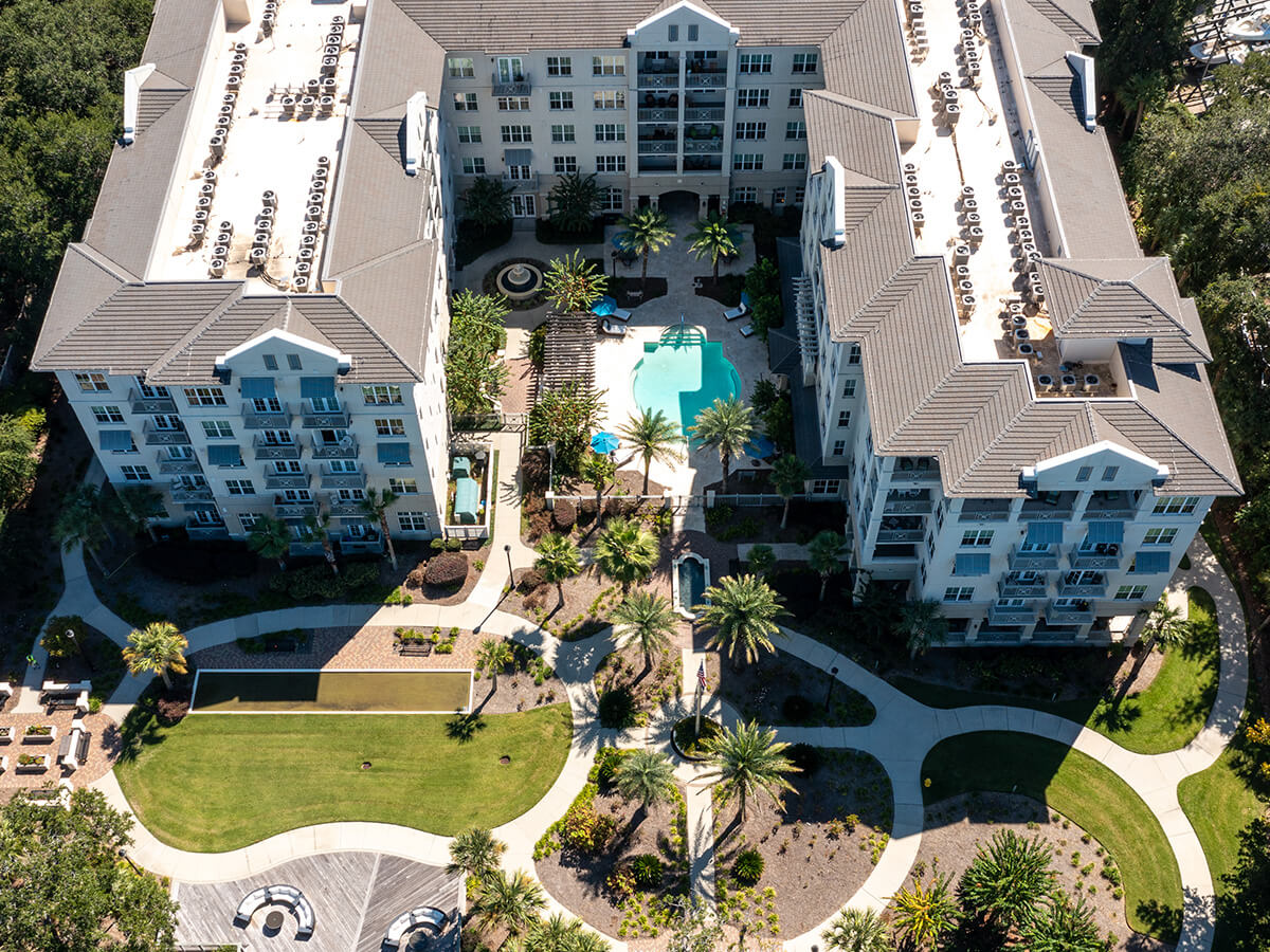 Aerial view of residential units with landscaped grounds and a central swimming pool.