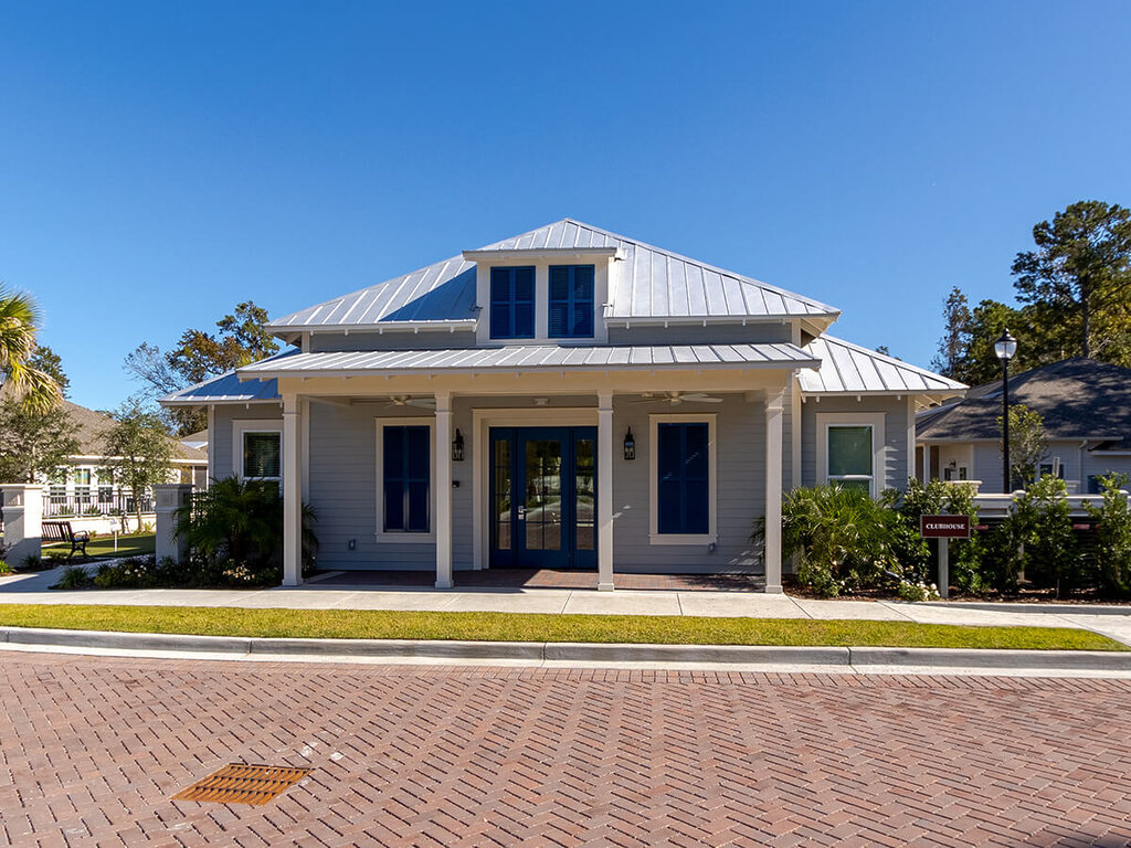 Front view of a community clubhouse with a modern design and landscaped surroundings.