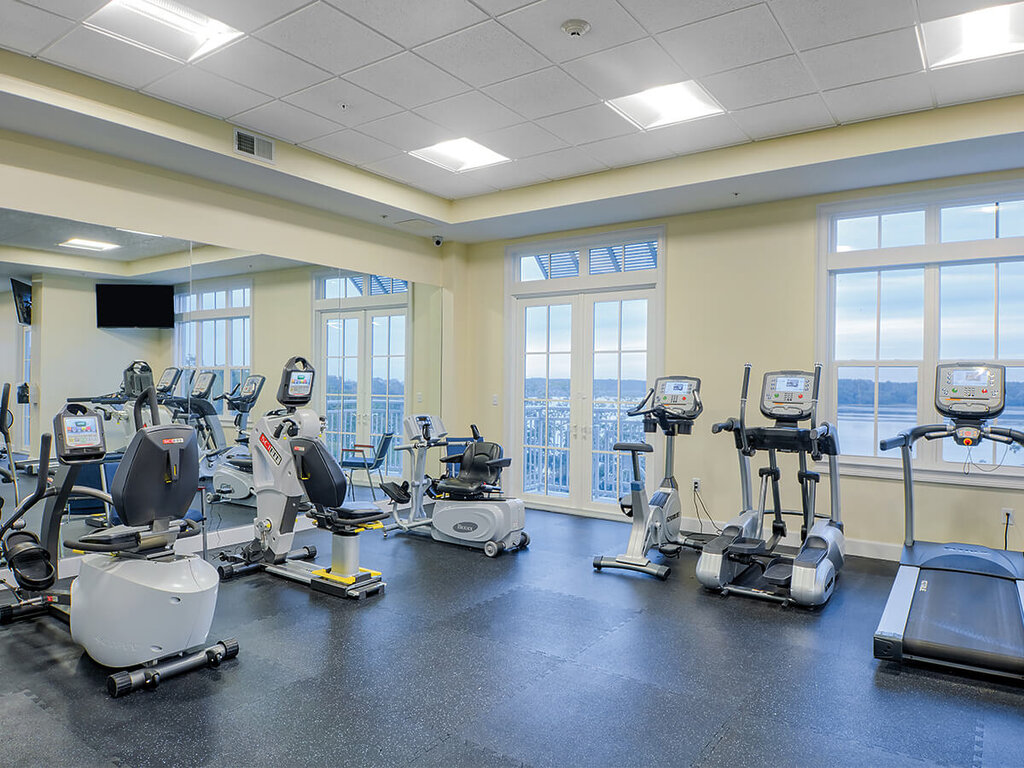 Bright gym with exercise bikes and treadmills in a community building.