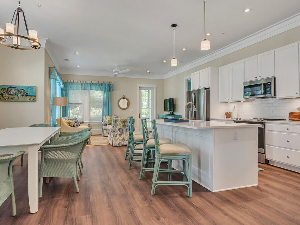 Spacious senior living unit with modern kitchen, dining area, and cozy seating.