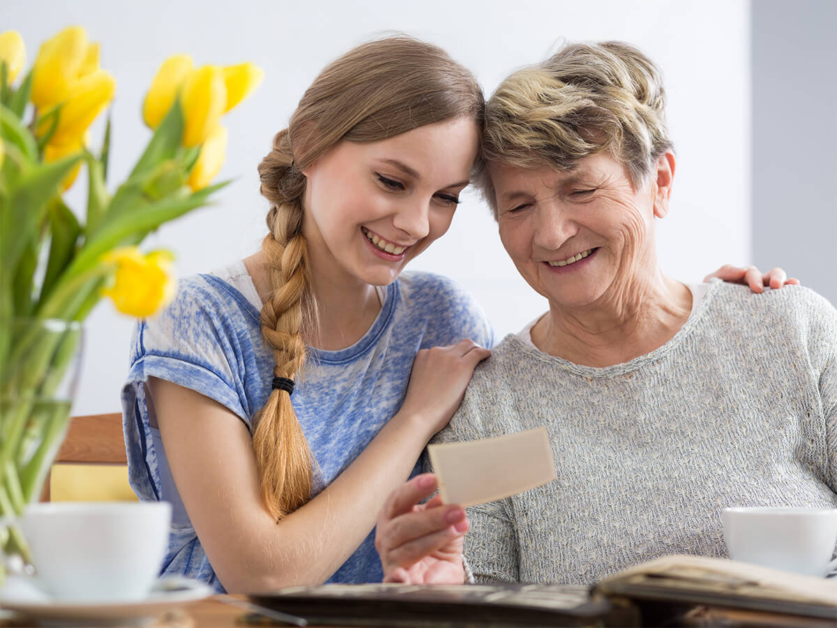 grandmother showing photos to granddaughter