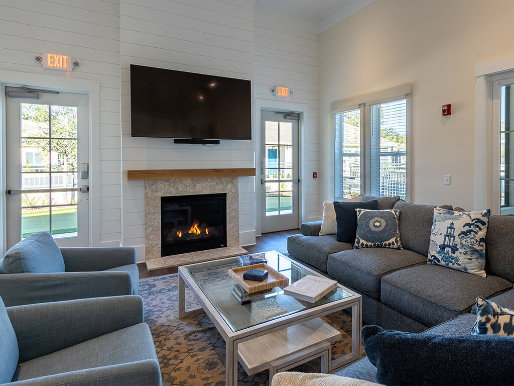 Cozy lounge with fireplace, plush seating, and a large television.
