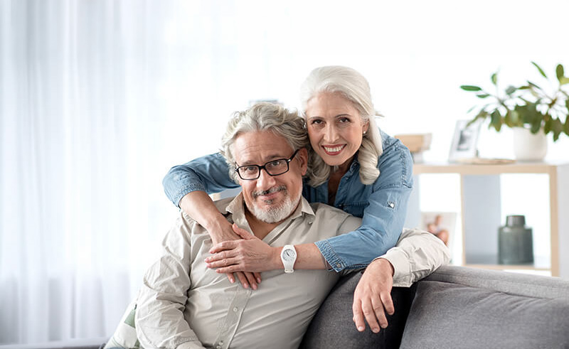 Smiling senior couple enjoys a cozy moment in their modern living room.