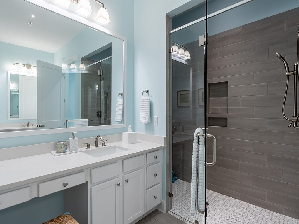 Modern bathroom with glass shower and vanity in a senior living unit.