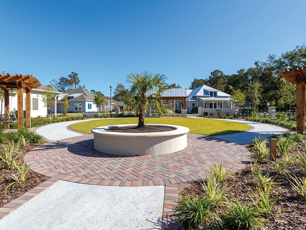 Spacious courtyard with circular walkway and modern units in a senior community.