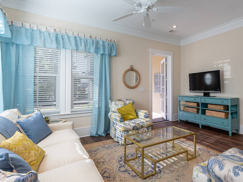 Cozy living room in a senior unit with blue accents and a wall-mounted TV.
