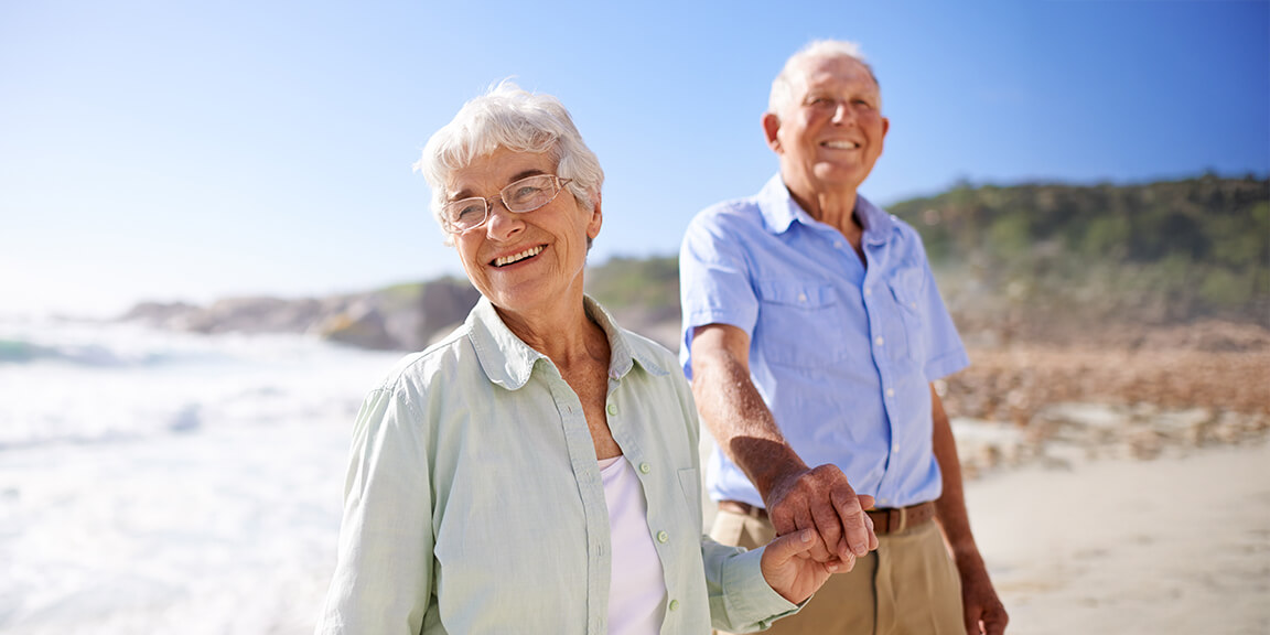 Senior couple walking on the beach together