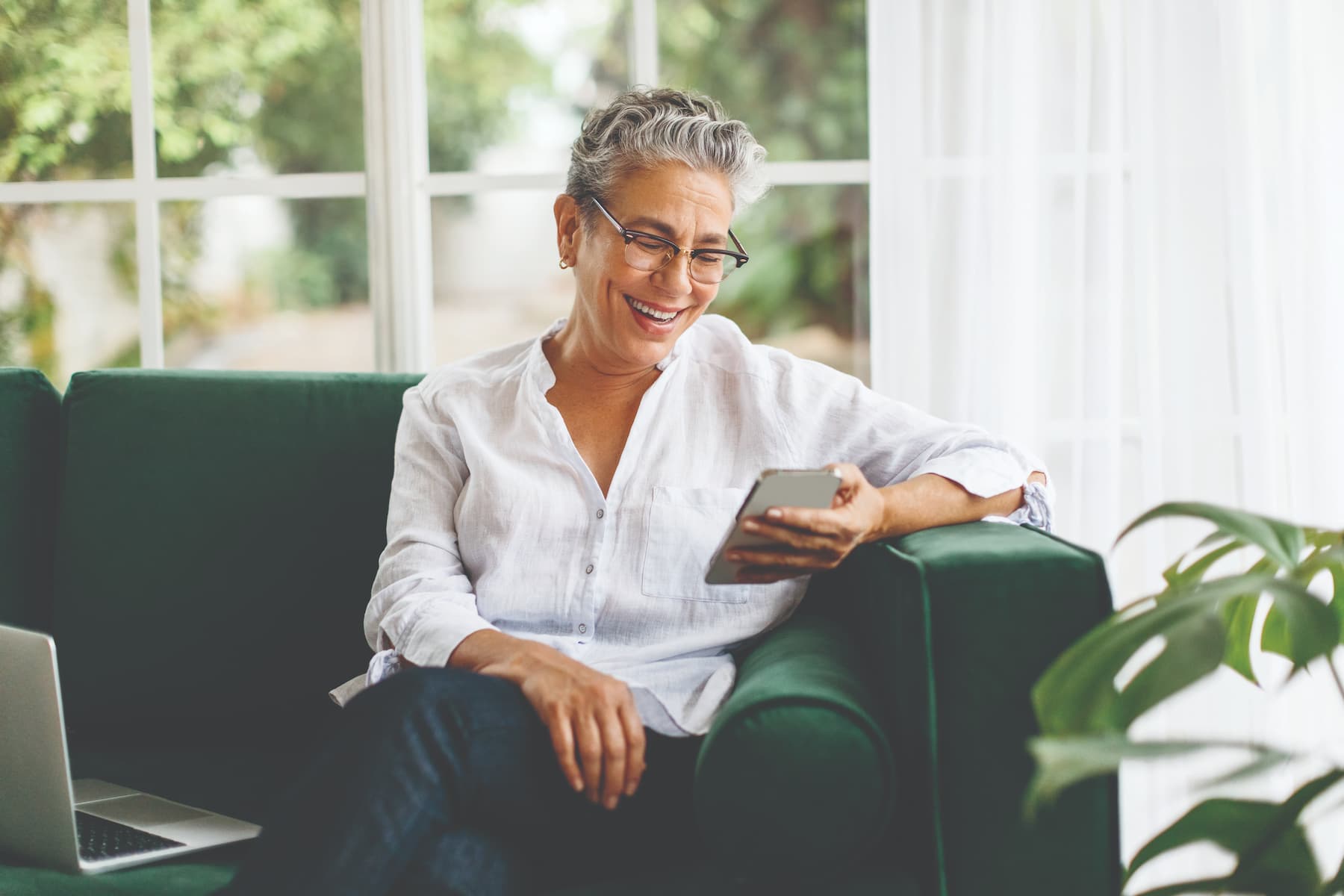 Senior woman smiling as she sits on the couch